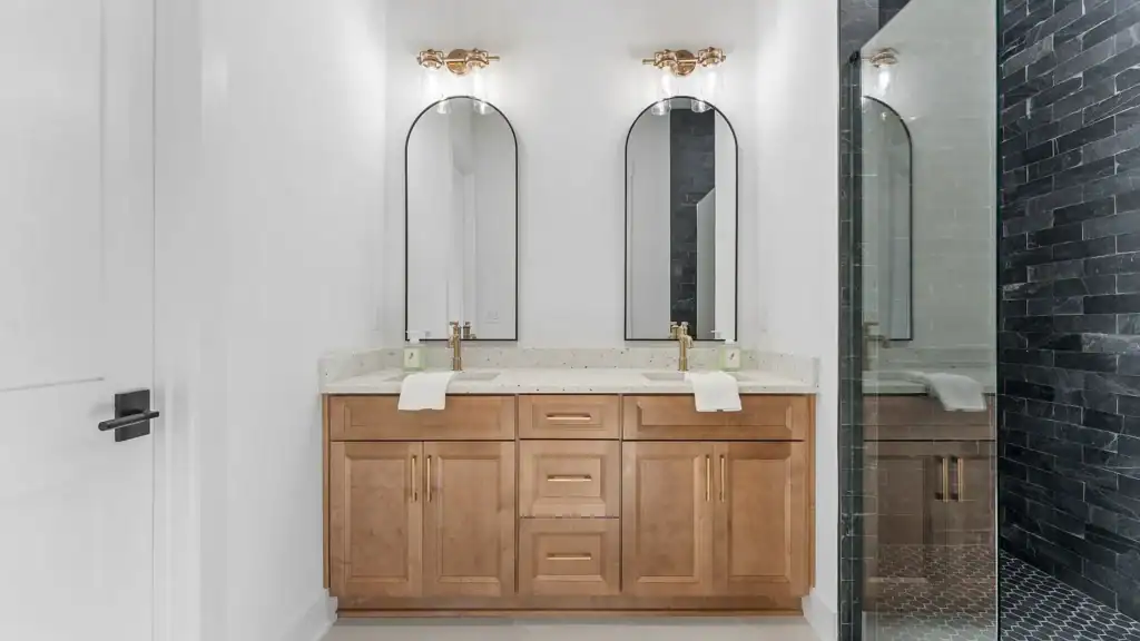 c83953fbe94923067e086ef756bf83a0-uncropped_scaled_within_1536_1152 Modern bathroom vanity with dual sinks and gold fixtures at Bertamini Development, showcasing high-end residential design.