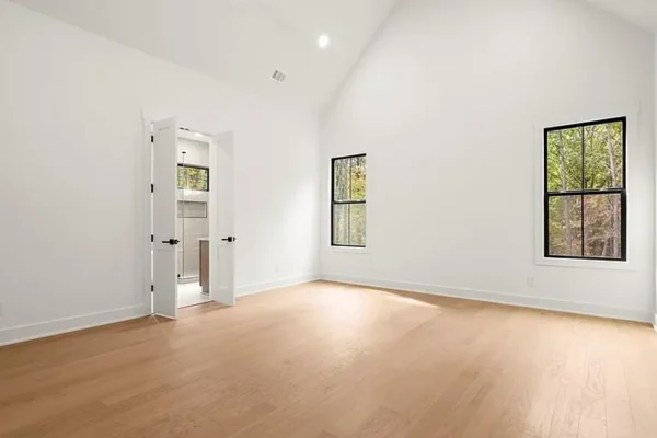 Bright spacious new home interior with large windows and hardwood floors, ideal for modern residential projects.