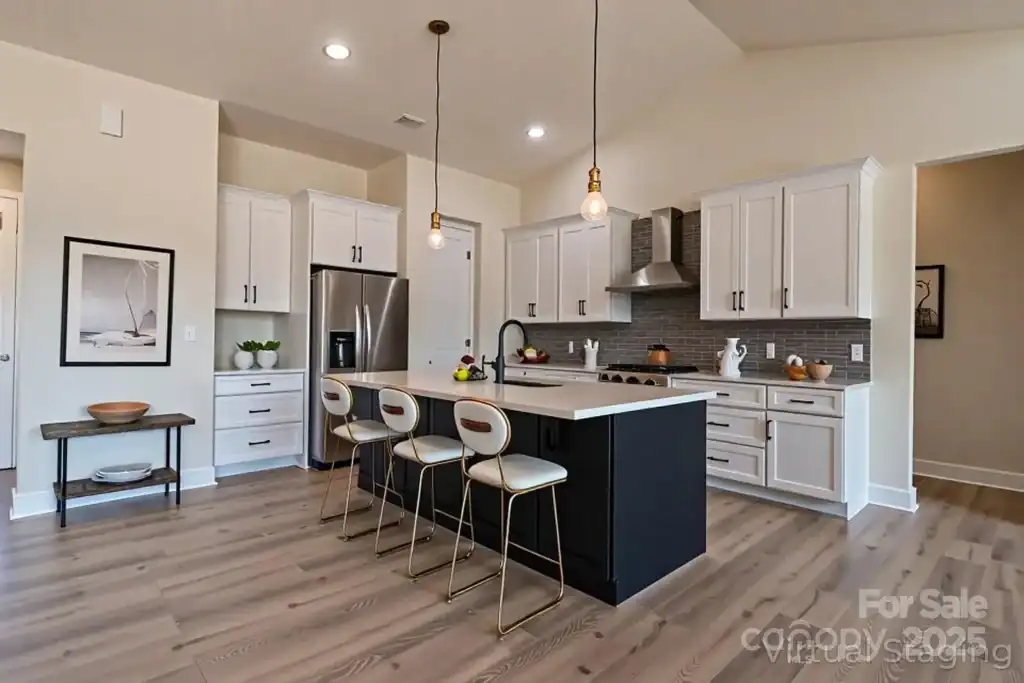 a9f9171b0e050f74afb3cbbca5c9b3bf-uncropped_scaled_within_1536_1152 Modern white and navy kitchen with island, pendant lighting, and hardwood floors.